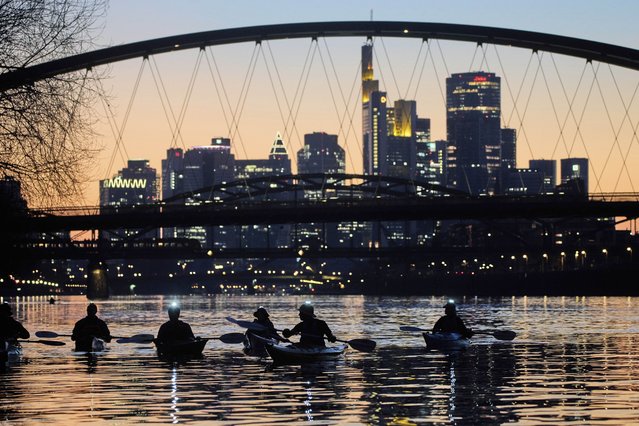 Paddlers use lights on their helmets as they navigate the River Main in Frankfurt, Germany, late Thursday, March 27, 2025. (Photo by Michael Probst/AP Photo)