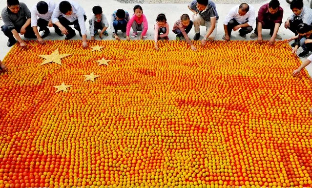 Villagers place persimmons in the shape of a Chinese national flag, ahead of China's upcoming National Day, in Shangrao, Jiangxi province, September 29, 2015. October 1 is China's National Day. This year, it marks the 66th anniversary of the founding of the People's Republic of China. (Photo by Reuters/Stringer)