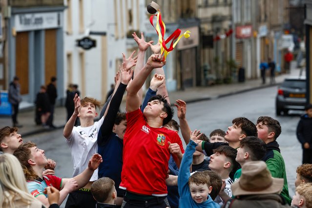 Youths chase after the leather ball during the annual “Fastern Eve Handba” event in Jedburgh's High Street in the Scottish Borders on February 15, 2024 in Jedburgh, Scotland. The annual event, which started in the 1700's, takes place today and involves two teams, the Uppies (residents from the higher part of Jedburgh) and the Doonies (residents from the lower part of Jedburgh) getting the ball to either the top or bottom of the town. The ball which is made of leather, stuffed with straw and decorated with ribbons is thrown into the crowd to begin the game. (Photo by Jeff J. Mitchell/Getty Images)