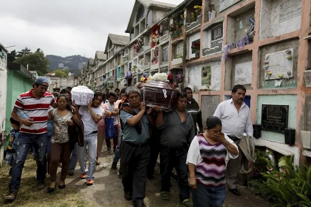 Relatives attend the funeral of two victims of a mudslide in Santa Catarina Pinula, on the outskirts of Guatemala City, October 3, 2015. Rescue workers scrabbled through earth and rubble on Saturday in search of survivors of a massive landslide in Guatemala that killed at least 48 people, even as hopes began to fade for hundreds of others still missing. (Photo by Jose Cabezas/Reuters)