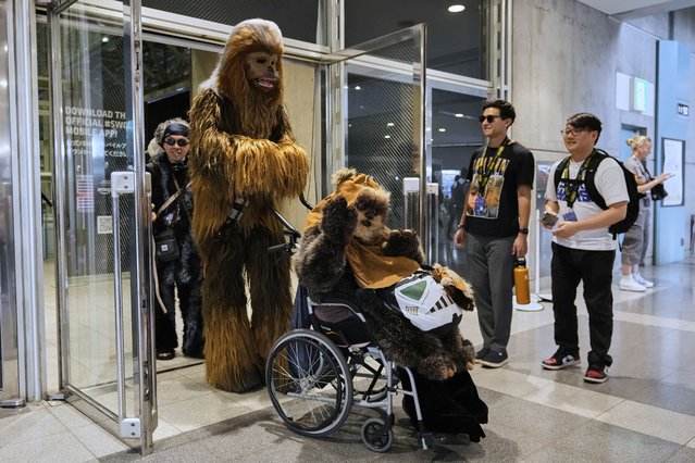 Star Wars fans wearing costumes of Chewbacca, left, and Widdle Warrick pose for a photo during a fan convention called the Star Wars Celebration in Chiba, near Tokyo, Friday, April 18, 2025. (Photo by Hiro Komae/AP Photo)