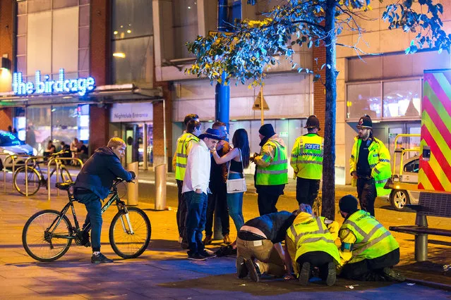 Taxi marshals help a woman , lying collapsed on the pavement on Withy Grove in Manchester, UK on September 11, 2016, as an ambulance arrives. (Photo by Joel Goodman/London News Pictures)