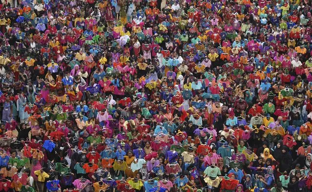 Students display the painted liquid embroidery blouses inside their college premises in Chennai, India, October 9, 2015. 3,500 students painted 7000 blouses in an hour on Friday in an attempt to enter the Limca Book of Records, a media release said. (Photo by Reuters/Stringer)