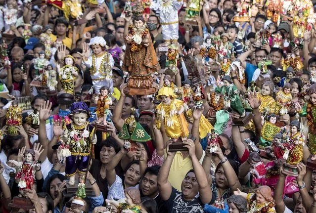 Residents carry religious icons of the baby Jesus during the annual Sto Nino (baby Jesus) feast in Manila on January 21, 2018. The Philippines is Asia's Catholic bastion with a flock of more than 80 million. Spain colonised the archipelago  in the 16th century and spread the faith. (Photo by Noel Celis/AFP Photo)