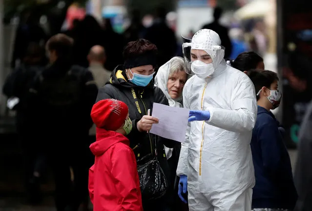 People speaking to a medical staff member wait to be tested for the coronavirus disease (COVID-19) at a sampling station in Prague, Czech Republic, September 29, 2020. (Photo by David W. Cerny/Reuters)