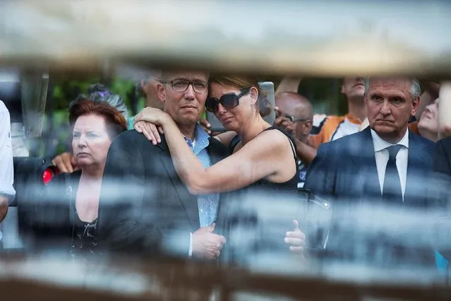 Family members of the victims killed in Malaysia Airlines Flight MH17 plane disaster are seen reacting next to Mayor Pieter Broertjes (R) through the window of a hearse carrying the victims' bodies as they arrive at the Korporaal van Oudheusden barracks, in Hilversum July 23, 2014. (Photo by Michael Kooren/Reuters)