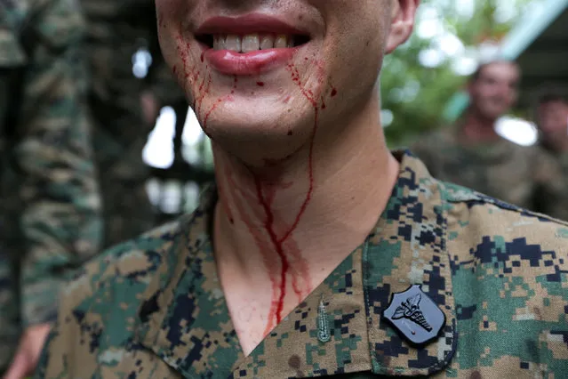 A U.S. Marine smiles as blood from a cobra drips from his mouth during a jungle survival exercise as part of the “Cobra Gold 2018” (CG18) joint military exercise, at a military base in Chonburi province, Thailand, February 19, 2018. (Photo by Athit Perawongmetha/Reuters)