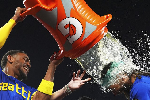 Seattle Mariners' Julio Rodriguez, left, douses J.P. Crawford after Crawford hit a game-winning home run to beat the Texas Rangers in a baseball game in Seattle, August 1, 2025. (Phoot by Lindsey Wasson/AP Photo)
