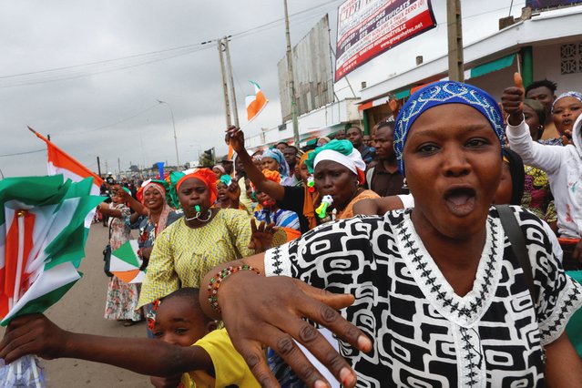 Residents of Bouake hold Ivory Coast flags during the arrival of Ivory Coast's President Alassane Ouattara (not pictured), one day ahead of Ivory Coast 65th independence anniversary day in Bouake, Ivory Coast on August 6, 2025. (Photo by Luc Gnago/Reuters)