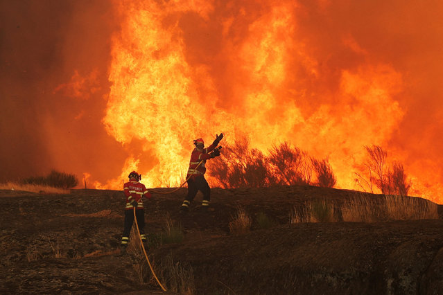 Firefighters work to extinguish a wildfire approaching Trancoso, Portugal on August 13, 2025. (Photo by Pedro Nunes/Reuters)