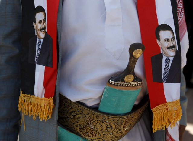 A man wears images of Yemen's former President Ali Abdullah Saleh during a demonstration against the Saudi-led air strikes outside the United Nations offices in Yemen's capital Sanaa October 18, 2015. (Photo by Khaled Abdullah/Reuters)