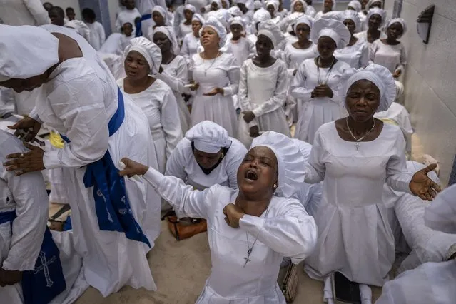 Members of the congregation sing and chant during a church service in which they prayed for the country ahead of elections and against the forces of evil, at the Celestial Church of Christ Olowu Cathedral on Lagos Island in Nigeria Friday, February 24, 2023. Nigerian voters are heading to the polls Saturday to select a new president following the second and final term of incumbent President Muhammadu Buhari. (Photo by Ben Curtis/AP Photo)