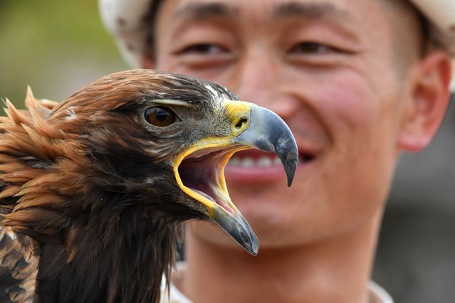 A Kyrgyz “berkutchi” (an eagle hunter) holds his golden eagle, during the hunting festival “Salburun”, in the village of Bokonbayev, near Lake Issyk-Kul, on August 2, 2025. (Photo by Vyacheslav Oseledko/AFP)