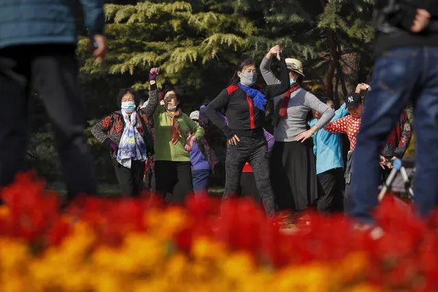 Women, some wearing face masks to help curb the spread of the coronavirus, practice social dance at a park in Beijing, Thursday, November 5, 2020. China is suspending entry for most foreign passport holders who reside in Britain, reacting to a new surge of coronavirus cases in the United Kingdom. (Photo by Andy Wong/AP Photo)