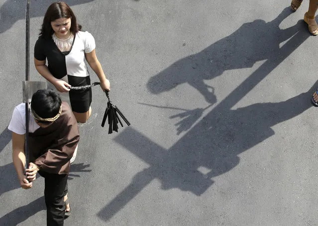 Protesters carrying wooden crosses reenact the sufferings of Jesus Christ during a rally on holy week in Manila, Philippines on Tuesday, March 27, 2018. The group used the demonstration to dramatize the plight of the urban poor under the government of Philippine President Rodrigo Duterte. (Photo by Aaron Favila/AP Photo)