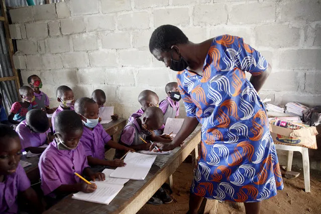 A teacher conducts a class at the Bright Achievers tuition-free school in the Bariga slum settlement, in Lagos, Nigeria, 13 November 2020. Bright Achievers, founded in 2017, is a tuition-free school in the Bariga district, a slum settlement with many underprivileged children whose parents mostly cannot afford sending their children to private and public schools. Most public schools in the Bariga district are congested and like in most slum settlements in Nigeria, are often in a state of disrepair. Seun Awobajo, founder of the school, who is also a drama director, says the school runs on voluntary donations from friends and on his personal finances, as he adopted twenty-seven of the students as either orphans or homeless children. (Photo by Akintunde Akinleye/EPA/EFE/Rex Features/Shutterstock)