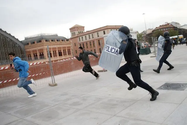 Police charge protesters during an anti-austerity demonstration in Madrid April 25, 2013.  Members of a the “Stand up!” platform called on people to stage an “indefinite siege” around parliament with the objective of “liberating” it according to the platform's website. Over a thousand police reportedly called in to guard the area around the Spanish parliament as authorities feared violent groups would attempt to cause havoc during the demonstration. (Photo by Juan Medina/Reuters)