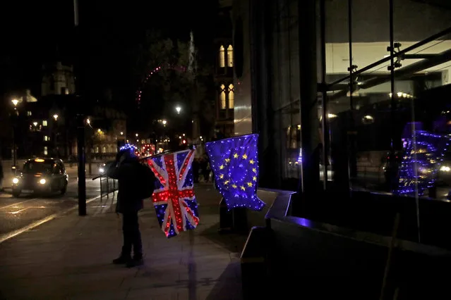 A pro-European Union membership supporter protests with illuminated European and Union flags outside Brexit trade negotiations between Britain and the EU at the Conference Centre in London, Friday, December 4, 2020. With less than one month to go before the U.K. exits the EU's economic orbit, talks are continuing, and U.K. officials have said this is the last week to strike a deal. (Photo by Matt Dunham/AP Photo)