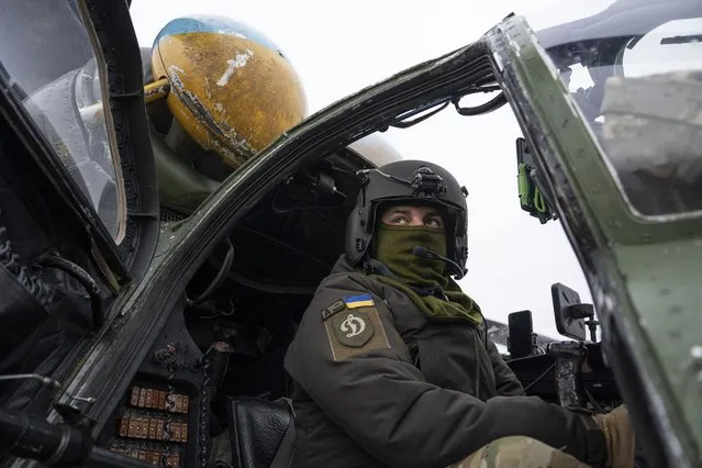 A Ukrainian pilot prepares for a flight on his Mi-24 attack helicopter during during a combat mission in Donetsk region, Ukraine, Saturday, March 18, 2023. (Photo by Evgeniy Maloletka/AP Photo)