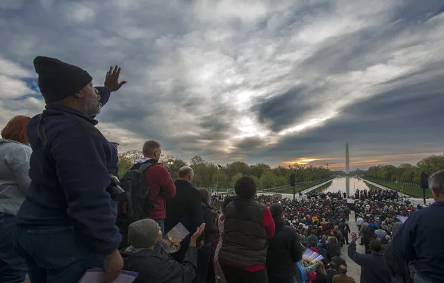 Participants sing hymns as the sun attempts to break  through clouds as the Capitol Church leads the 36th annual sunrise Easter service at the Lincoln Memorial on April, 20, 2014 in Washington, DC. (Photo by Bill O'Leary/The Washington Post)