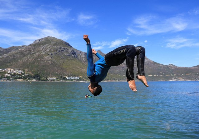 A man dives into the water during a sunny day at Hout Bay harbour in Cape Town, South Africa, on October 9, 2025. (Photo by Esa Alexander/Reuters)