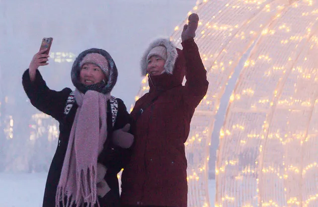 Local women pose for a selfie in Lenin Square in freezing conditions of minus 43 degrees Celsius in the city of Yakutsk, Sakha (Yakutia) on December 13, 2020. Located in Russia's Far East, Yakutia is known for its severe climate. (Photo by Yevgeny Sofroneyev/TASS)