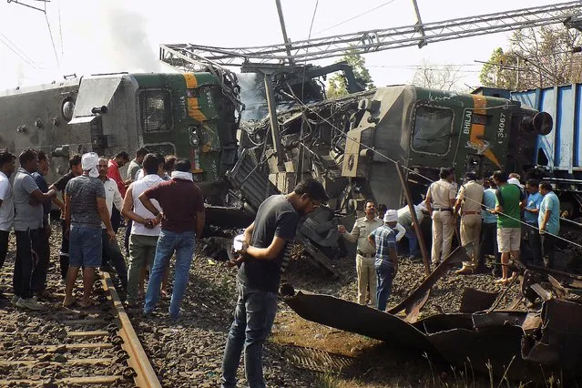People gather around the wreckage of two goods trains after a collision near Singhpur Railway Station some 146 km from Jabalpur on April 19, 2023. (Photo by AFP Photo/Stringer)