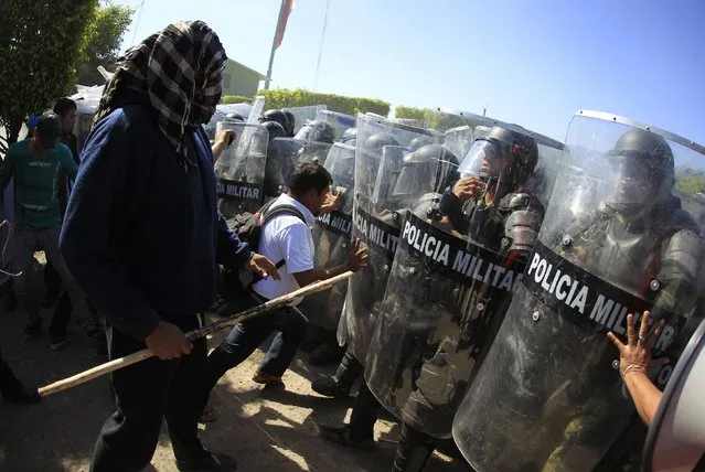 Activists and relatives of the 43 missing trainee teachers from Ayotzinapa's teacher training college confront the military police officers during a demonstration at the military zone of the 27th infantry battalion, in Iguala, Guerrero, January 12, 2015. (Photo by Jorge Dan Lopez/Reuters)