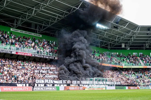 Supporters of FC Groningen ignite smoke bombs during the Dutch Eredivisie match  between FC Groningen and Ajax Amsterdam at Euroborg stadium in Groningen, Netherlands, 14 May 2023. (Photo by Cor Lasker/EPA)