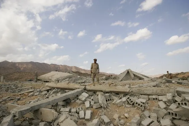 An army officer stands on the ruins of a police barracks, which was bombed by al Qaeda insurgents, at al-Mahfad, in the southern Yemeni province of Abyan May 23, 2014. (Photo by Khaled Abdullah/Reuters)