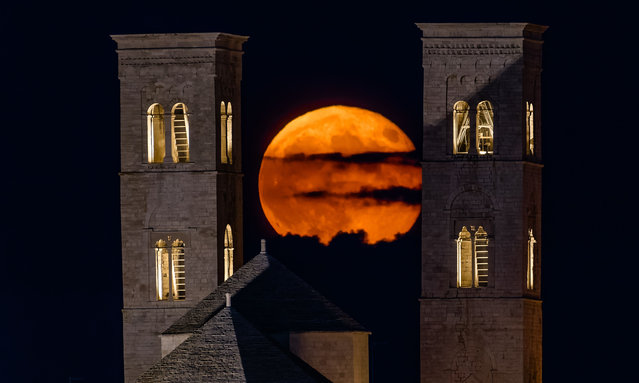 The September Supermoon, also called the Full Harvest Moon, rises between the towers of Molfetta Cathedral in Molfetta, Italy, on September 18, 2024. (Photo by Davide Pischettola/NurPhoto/Rex Features/Shutterstock)