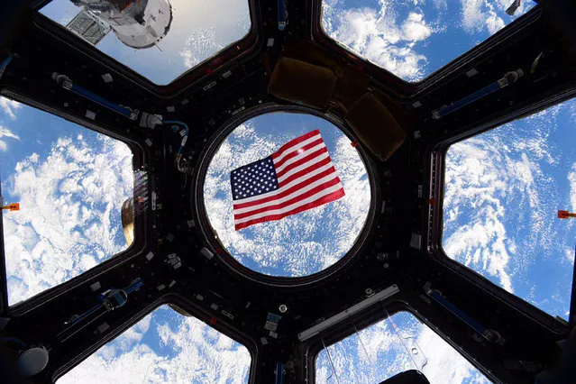 An American flag is framed in the windows of the International Space Station. Photo taken by astronaut Kjell Lindgren and released November 11, 2015. (Photo by Kjell Lindgren/Reuters/NASA)