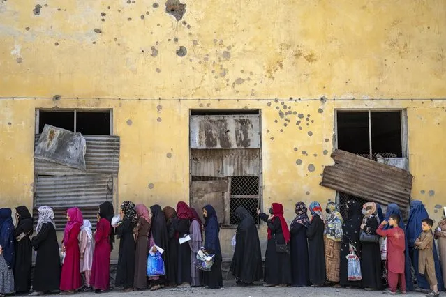 Afghan women wait to receive food rations distributed by a humanitarian aid group, in Kabul, Afghanistan, Sunday, May 28, 2023. (Photo by Ebrahim Noroozi/AP Photo)