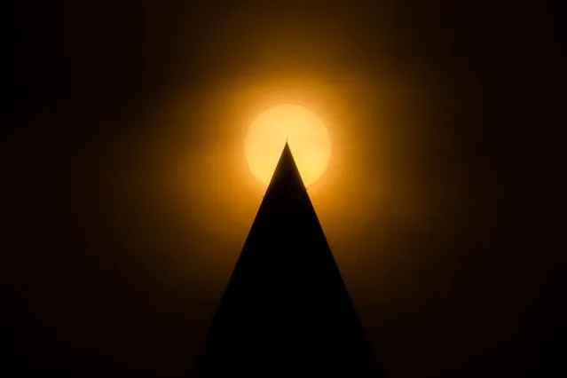 Smoke from Canadian wildfires casts a haze over the sun as it passes behind the tip of the Washington Monument in the evening in Washington, DC, USA, 07 June 2023. DC issued a code red air quality alert as a result of the smoke, which is affecting large portions of the northeastern United States. (Photo by Jim Lo Scalzo/EPA/EFE)