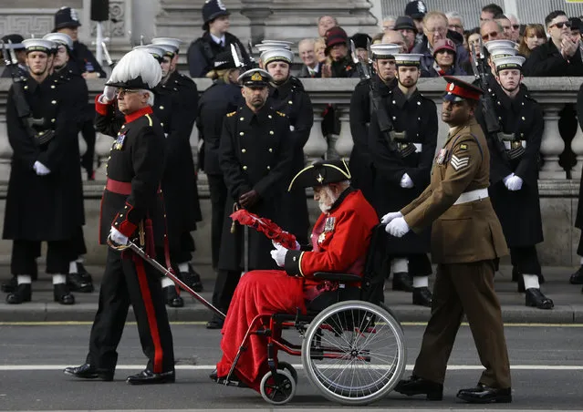 Sargent Johnson Beharry VC, wheels a Chelsea Pensioner past the Cenotaph as he gets ready to hand over his wreath during the Remembrance Sunday service at the Cenotaph in London, Sunday, November13, 2016. (Photo by Alastair Grant/AP Photo)