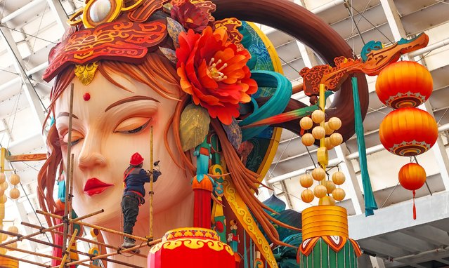 A worker sets up a giant lantern in the traditional Chinese style at China Railway Qingdao World Expo City in preparation for a lantern festival to welcome the upcoming 2025 Chinese New Year, the Year of the Snake, on January 4, 2025 in Qingdao, Shandong Province of China. (Photo by Zhang Jingang/VCG via Getty Images)