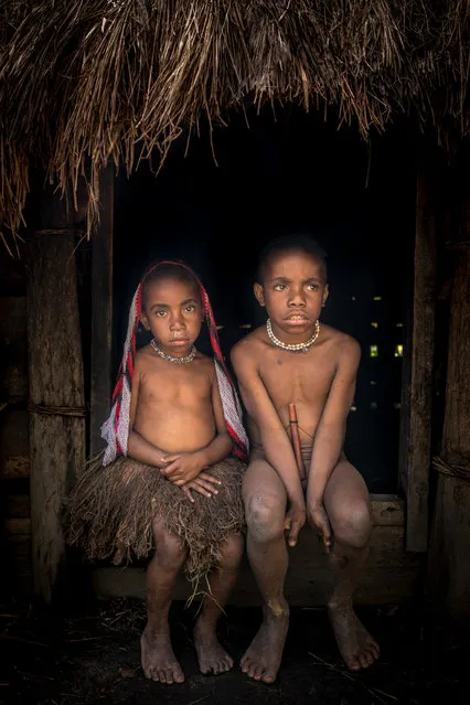 Young boy and girl from Dani tribe sit inside a hut in, Western New Guinea, Indonesia, August 2016. (Photo by Teh Han Lin/Barcroft Images)