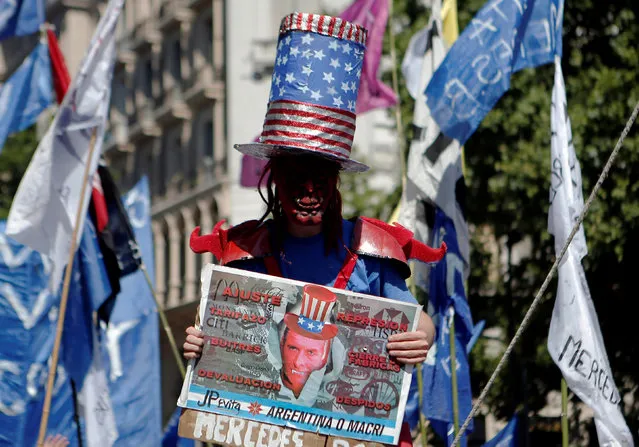 A demonstrator holds a poster showing the face of Argentine President Mauricio Macri during a protest staged by social organizations and unions outside the Congress demanding an increase in social security payments and in support of an opposition-backed bill that seeks payments to the poorest families and create more new jobs, in Buenos Aires, Argentina November 18, 2016. (Photo by Agustin Marcarian/Reuters)