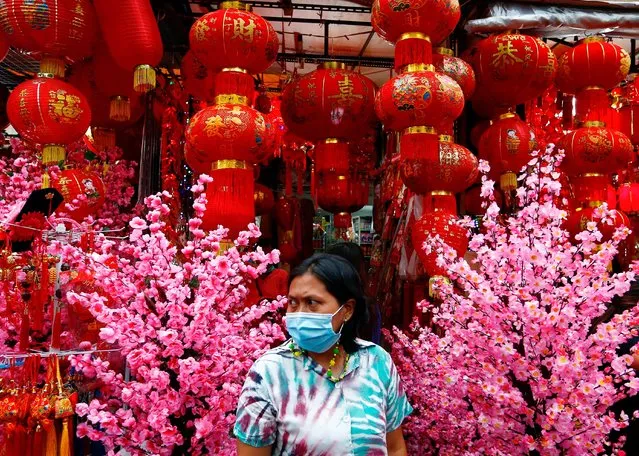 Vendor wearing a protective mask stands as she waits for customers at a street market selling decorations for the Lunar New Year in Jakarta, Indonesia, February 4, 2021. (Photo by Ajeng Dinar Ulfiana/Reuters)