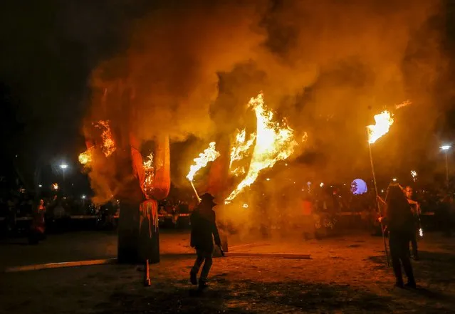 Revellers take part in the 26th Annual Kensington Market Winter Solstice Parade as they burn a giant hand structure in Toronto, December 21, 2015. (Photo by Mark Blinch/Reuters)