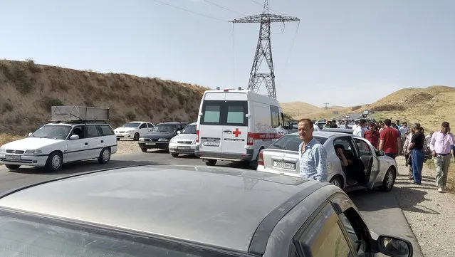 In this photo taken on Sunday, July 29, 2018, an ambulance arrives where four tourists were killed when a car rammed into a group of foreigners on bicycles south of the capital of Dushanbe, Tajikistan. The Islamic State group on Tuesday claimed responsibility for a car-and-knife attack on Western tourists cycling in Tajikistan that killed two Americans and two Europeans. (Photo by Zuly Rahmatova/AP Photo)