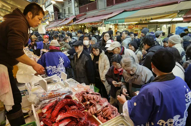 People crowd around a fishmonger's in Ameya-Yokocho street as they do their food shopping in Tokyo, Japan, 29 December 2015, in preparation for the upcoming New Year. People are busy stocking up in preparation for the end of the year and New Year's holidays. (Photo by Kimimasa Mayama/EPA)