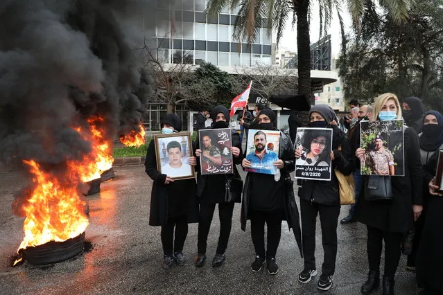 Relatives of victims of Beirut port explosion stand near burning tires during a protest, after a Lebanese court removed the judge leading the investigation into the explosion, outside the Justice Palace in Beirut, Lebanon on February 19, 2021. (Photo by Mohamed Azakir/Reuters)