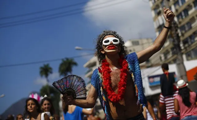 A reveller dances during the annual block party known as the “Suvaco do Cristo” (Armpit of Christ), one of the many pre-carnival parties to take place in the neighbourhoods of Rio de Janeiro, February 8, 2015. (Photo by Ricardo Moraes/Reuters)