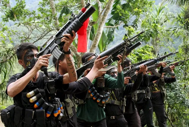 Armed members of the New People's Army (NPA) aim their weapons during an event commemorating the 47th anniversary of the founding of the Communist Party of the Philippines, in Ifugao province, north of Manila December 29, 2015. (Photo by Harley Palangchao/Reuters)
