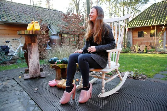 The daughter of Dutch wooden shoe maker Dirk Poffers displays a pair of clog pumps in Hellendoorn, on January 10, 2016. The shoe designer made a heeled modern version of the footwear to prevent the handicraft disappearing. (Photo by Bas Czerwinski/AFP Photo/ANP)