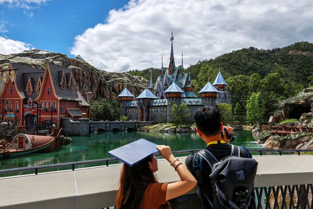 A videographer takes video at the world's first 'Frozen' themed land during a media preview tour at Disneyland in Hong Kong, China on September 12, 2023. (Photo by Tyrone Siu/Reuters)
