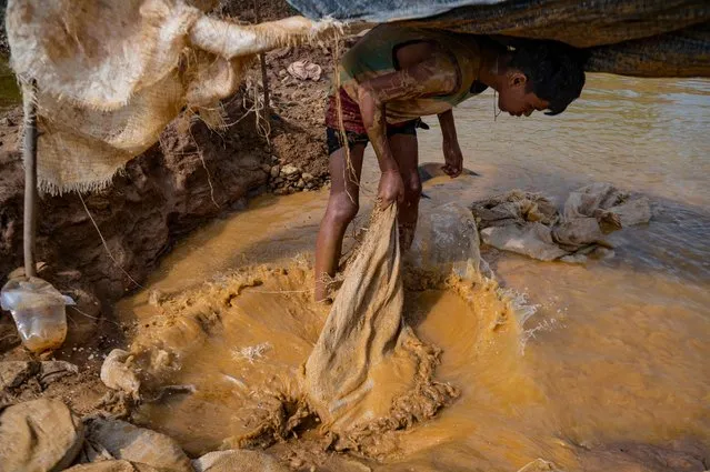 A young Venezuelan miner works in an open pit mine in search of gold to later sell it in El Callao, Bolivar State, Venezuela, on August 29, 2023. In the town of El Callao, extracting gold from soil starts off as a kid's game, but soon becomes a full-time job that human rights activists says amounts to child exploitation. (Photo by Magda Gibelli/AFP Photo)