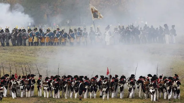 Performers wearing 19th century Allied forces and French military uniforms attack one another during a reenactment of the Battle of the Nations, in a field in the village of Markkleeberg near Leipzig October 20, 2013. The east German city of Leipzig commemorated the 200th anniversary of the largest battle of the Napoleonic Wars on Sunday by reenacting the Battle of the Nations, with 6,000 military-historic association enthusiasts from all over Europe. The decisive encounter in which tens of thousands of soldiers were killed, took place from October 17-19, 1813, just outside of Leipzig.  At the height of the hostilities Napoleon fielded more than 200,000 men against an Allied force of some 360,000 soldiers which included troops from Russia, Austria, Prussia and Sweden. (Photo by Fabrizio Bensch/Reuters)