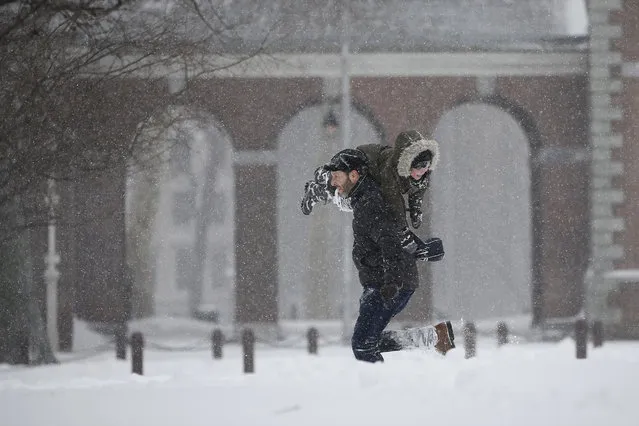 Enrique Rafalin, left, carries his nephew, Alajandro Rafalin, 5, as they play in the snow on Independence Mall, Saturday, January 23, 2016, in Philadelphia. (Photo by Matt Slocum/AP Photo)